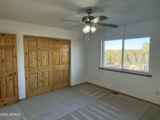 unfurnished bedroom with ceiling fan and light colored carpet