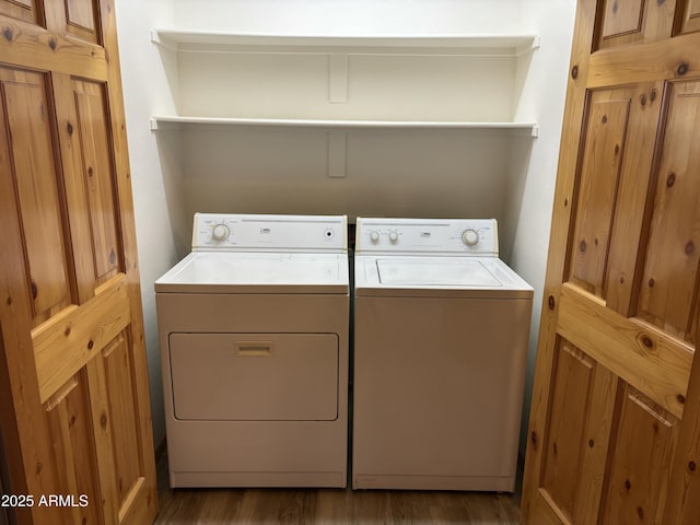 laundry room with washing machine and clothes dryer and dark wood-type flooring