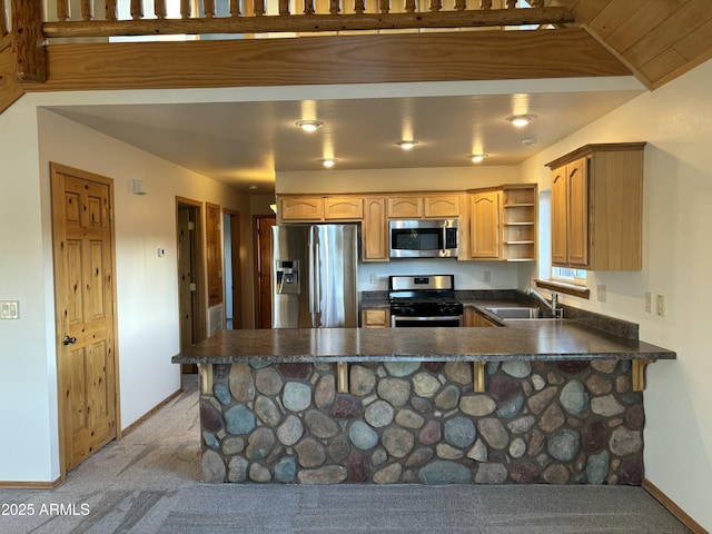 kitchen featuring lofted ceiling, light carpet, stainless steel appliances, sink, and kitchen peninsula