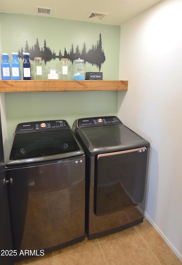 clothes washing area with light tile patterned floors and separate washer and dryer