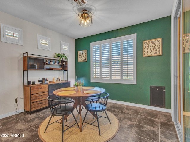 dining space with dark tile patterned flooring