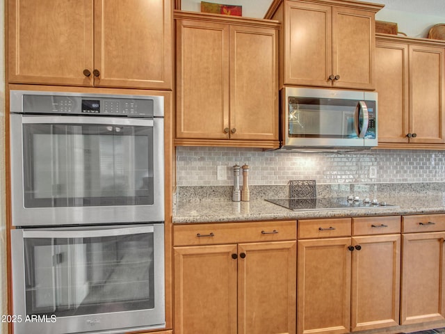 kitchen with light stone counters, backsplash, and stainless steel appliances