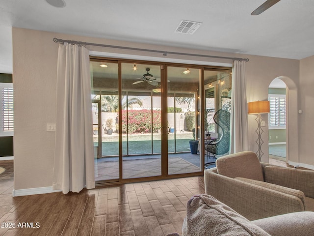 doorway to outside with wood-type flooring and ceiling fan