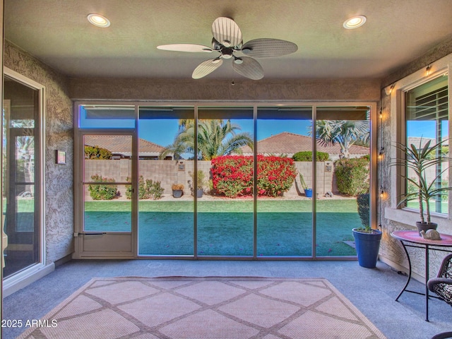 unfurnished sunroom featuring ceiling fan