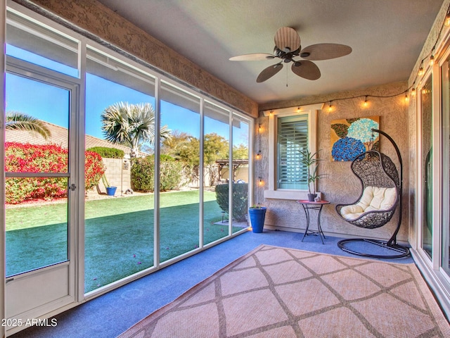 unfurnished sunroom featuring ceiling fan