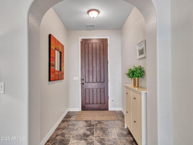 foyer entrance with a textured ceiling