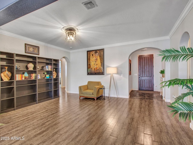 sitting room with hardwood / wood-style flooring, ornamental molding, and a textured ceiling