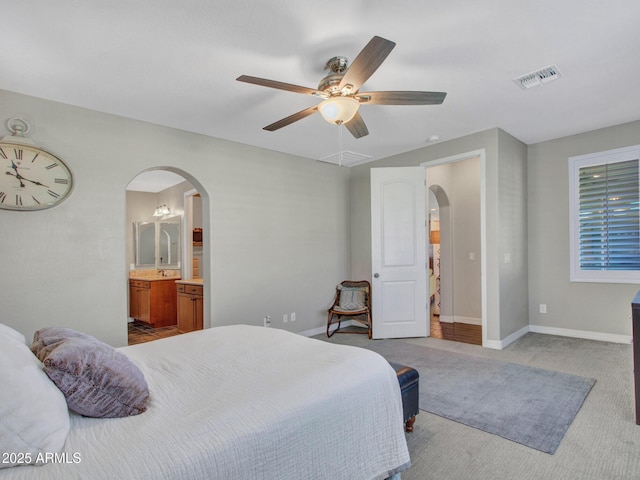 carpeted bedroom featuring connected bathroom and ceiling fan