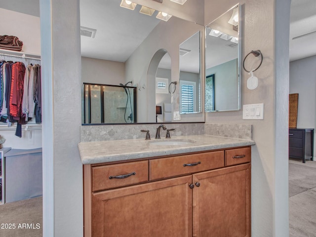 bathroom with vanity and a shower with shower door