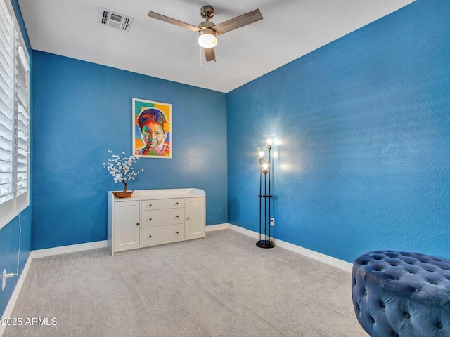 interior space with light colored carpet and ceiling fan