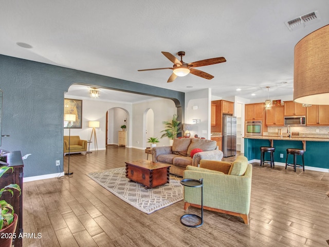 living room with ceiling fan, sink, and hardwood / wood-style floors