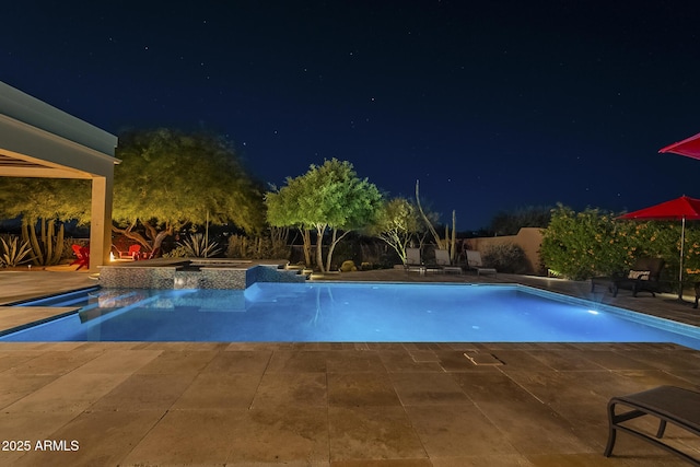 8248 E Arroyo Hondo Rd, Scottsdale, AZ 85266 - pool at night with a patio area, a fenced backyard, and a pool with connected hot tub