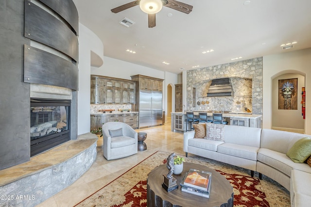 8248 E Arroyo Hondo Rd, Scottsdale, AZ 85266 - living room featuring arched walkways, a fireplace, ceiling fan, recessed lighting, and light tile patterned flooring