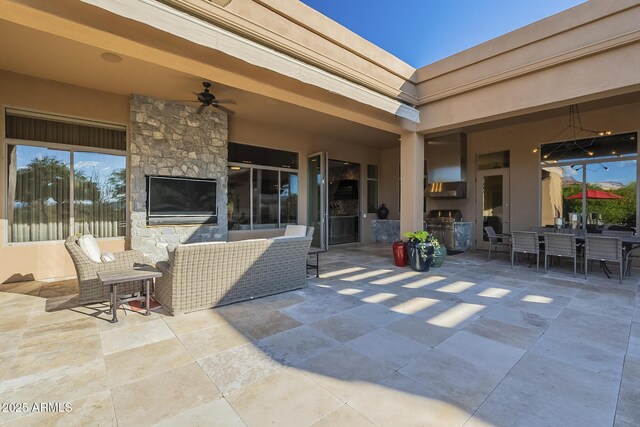 8248 E Arroyo Hondo Rd, Scottsdale, AZ 85266 - view of patio with an outdoor kitchen, an outdoor stone fireplace, outdoor dining space, and ceiling fan