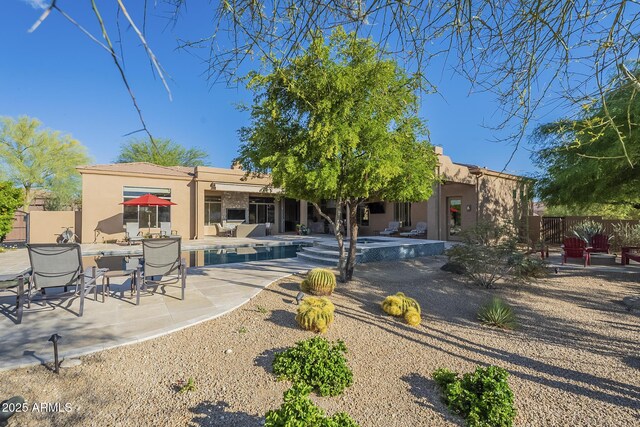 8248 E Arroyo Hondo Rd, Scottsdale, AZ 85266 - back of house featuring stucco siding, a patio area, an outdoor pool, and fence