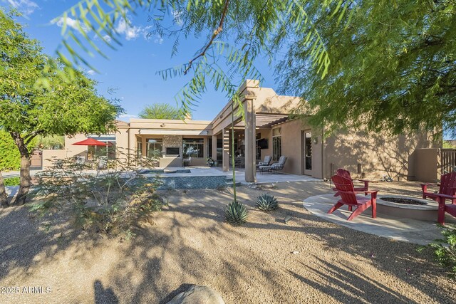 8248 E Arroyo Hondo Rd, Scottsdale, AZ 85266 - back of house with a fire pit, stucco siding, and a patio