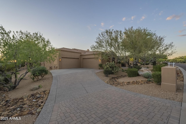 8248 E Arroyo Hondo Rd, Scottsdale, AZ 85266 - adobe home featuring a garage, decorative driveway, and stucco siding