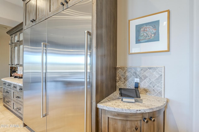 8248 E Arroyo Hondo Rd, Scottsdale, AZ 85266 - kitchen featuring stainless steel built in fridge, light stone counters, and decorative backsplash