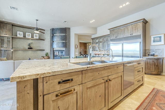 8248 E Arroyo Hondo Rd, Scottsdale, AZ 85266 - kitchen featuring a sink, light brown cabinetry, dishwasher, light stone counters, and a ceiling fan