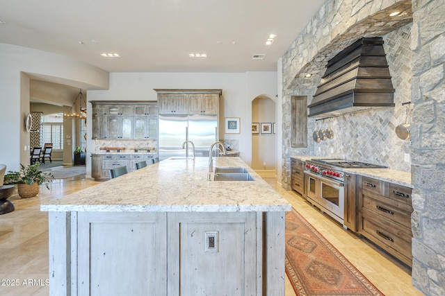 8248 E Arroyo Hondo Rd, Scottsdale, AZ 85266 - kitchen featuring a sink, high end appliances, tasteful backsplash, arched walkways, and recessed lighting