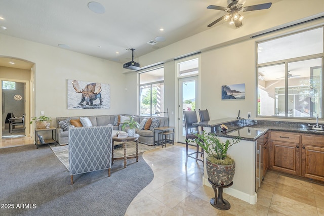 8248 E Arroyo Hondo Rd, Scottsdale, AZ 85266 - living room featuring light tile patterned floors, a ceiling fan, arched walkways, and recessed lighting