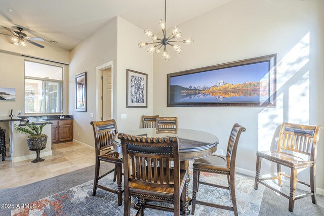 8248 E Arroyo Hondo Rd, Scottsdale, AZ 85266 - dining room featuring a chandelier, baseboards, ceiling fan, light tile patterned floors, and light carpet