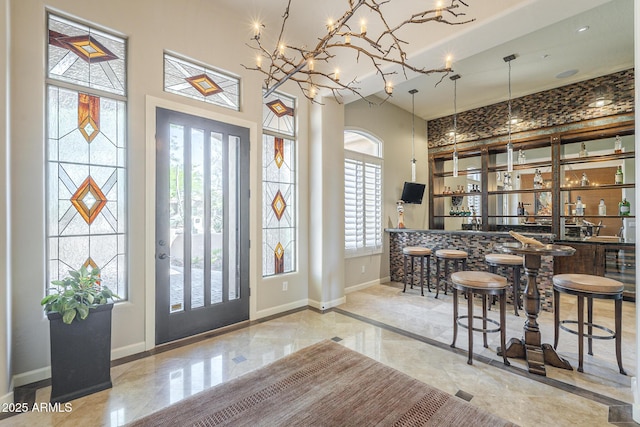 8248 E Arroyo Hondo Rd, Scottsdale, AZ 85266 - entrance foyer featuring baseboards, wet bar, a towering ceiling, beverage cooler, and inlaid floor details