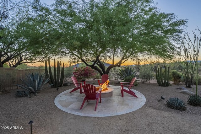 8248 E Arroyo Hondo Rd, Scottsdale, AZ 85266 - patio terrace at dusk with an outdoor fire pit and fence
