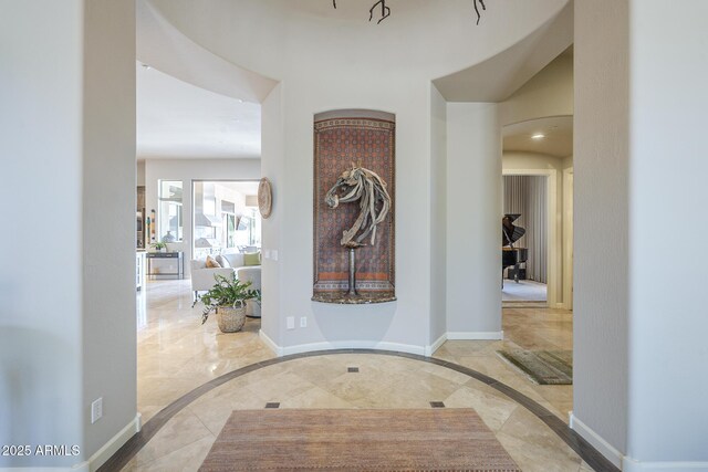 8248 E Arroyo Hondo Rd, Scottsdale, AZ 85266 - foyer featuring inlaid floor details, baseboards, and arched walkways