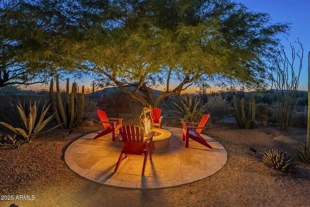 8248 E Arroyo Hondo Rd, Scottsdale, AZ 85266 - patio terrace at dusk featuring a fire pit and fence