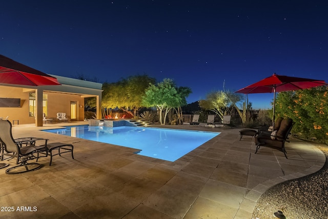 8248 E Arroyo Hondo Rd, Scottsdale, AZ 85266 - pool at night featuring a patio