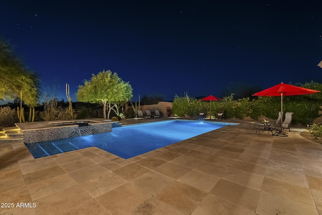 8248 E Arroyo Hondo Rd, Scottsdale, AZ 85266 - pool at night with a patio area and a pool with connected hot tub