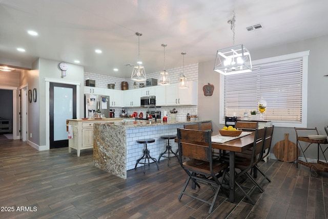 interior space with baseboards, dark wood finished floors, visible vents, and recessed lighting