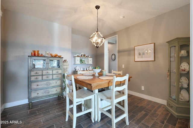 dining room with a chandelier, wood tiled floor, and baseboards