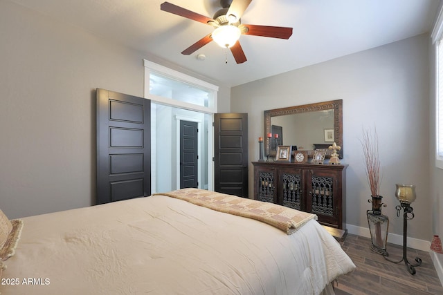 bedroom with ceiling fan, dark wood-style flooring, and baseboards