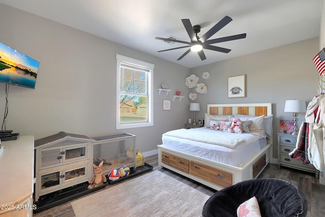 bedroom with ceiling fan, wood finished floors, and baseboards