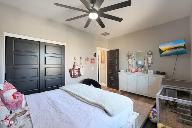 bedroom with visible vents, ceiling fan, and wood finished floors