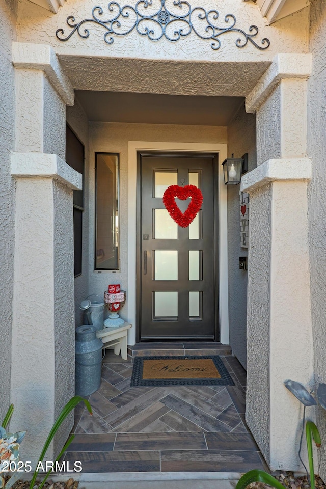 view of exterior entry with stucco siding