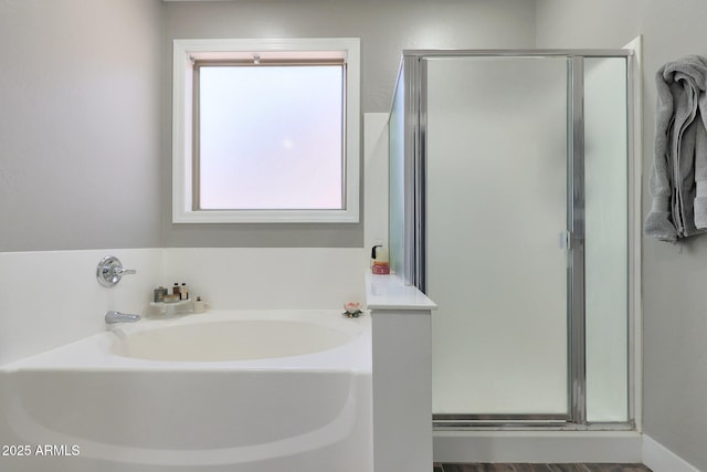 bathroom with a stall shower and a garden tub