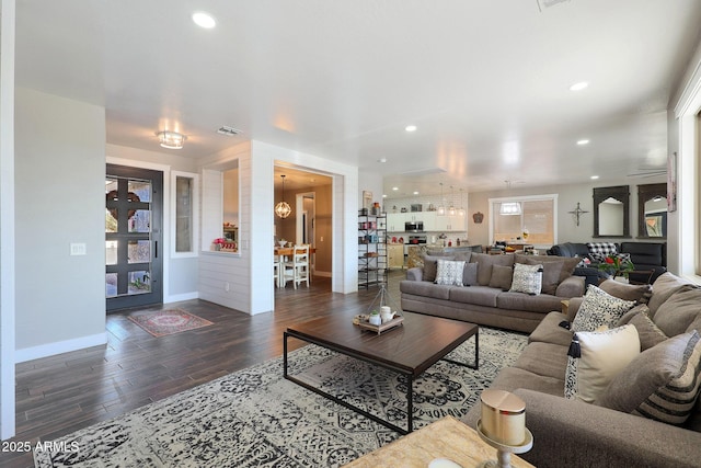 living room with baseboards, wood finished floors, visible vents, and recessed lighting