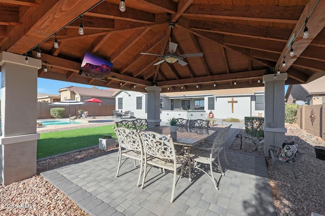 view of patio with a fenced in pool, outdoor dining area, a gazebo, ceiling fan, and a fenced backyard