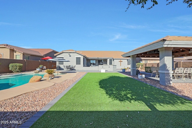 rear view of house with a lawn, a fenced in pool, a fenced backyard, a gazebo, and a patio area