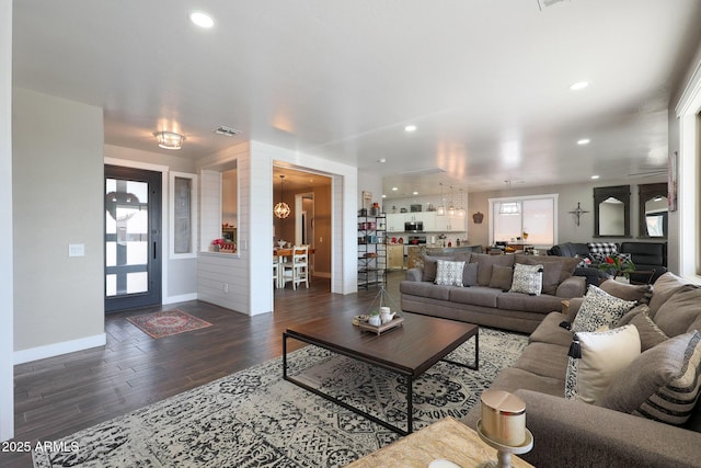 living area with recessed lighting, visible vents, baseboards, and wood finished floors