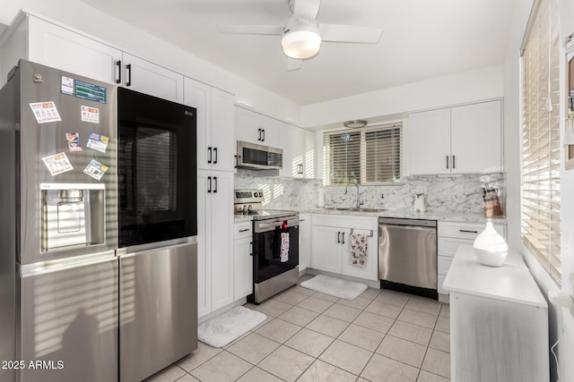 kitchen featuring ceiling fan, stainless steel appliances, white cabinetry, and sink