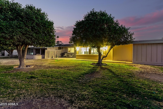 yard at dusk with a sunroom and a patio