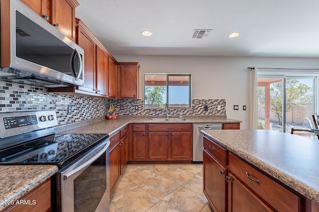 5305 E Silverbell Rd, San Tan Valley, AZ 85143 - kitchen featuring appliances with stainless steel finishes, a sink, backsplash, brown cabinets, and recessed lighting