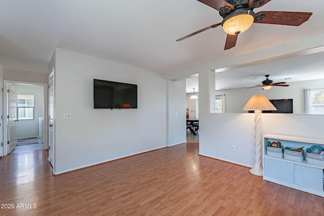 5305 E Silverbell Rd, San Tan Valley, AZ 85143 - unfurnished living room with ceiling fan, wood finished floors, and baseboards