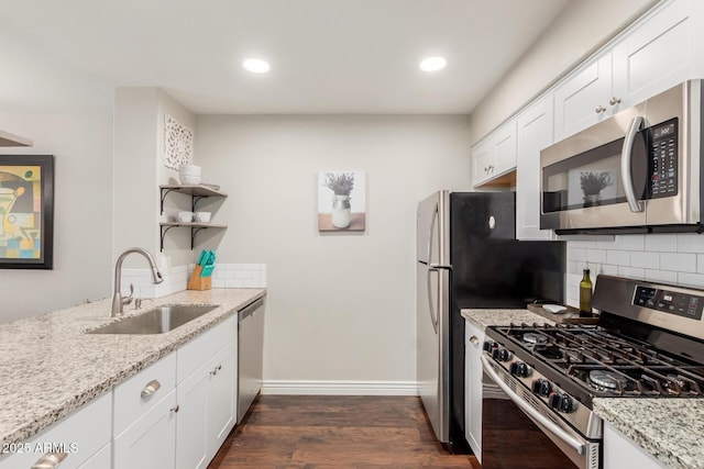 kitchen featuring dark wood-style floors, appliances with stainless steel finishes, a sink, open shelves, and backsplash