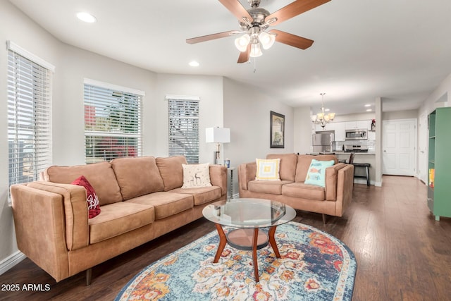 living room with ceiling fan with notable chandelier, dark wood-type flooring, baseboards, and recessed lighting