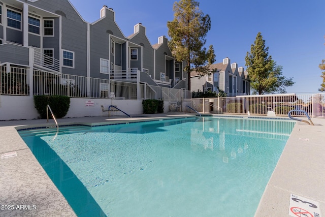 community pool featuring a residential view and fence